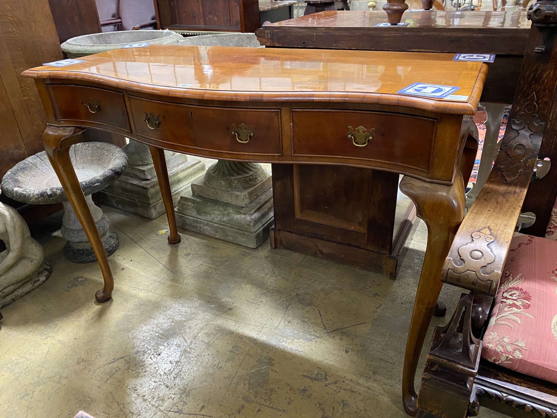 A reproduction Queen Anne revival walnut serpentine serving table, width 122cm, depth 53cm, height 87cm